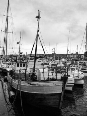 Monochrome image of fishing boats tied up in Reykjavik harbour in Iceland