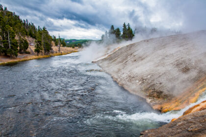 Boiling water pours from geysers into the Firehole River