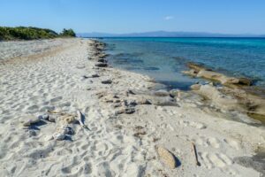 Afitos in Halkidiki Greece: Looking along a quiet Afitos beach on a summers afternoon
