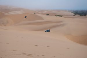 4x4s cross the dunes at Sandwich Harbour, Namibia