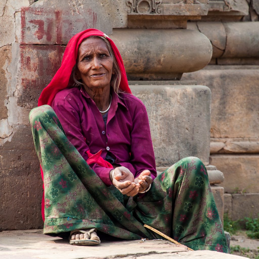 An old woman sits on  stone steps in the village of Abhaneri